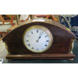 An Edwardian mahogany and boxwood lined table clock, the arched case with brass spindles and pad