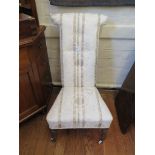 A Victorian upholstered prie-dieu chair, on turned legs with pot castors