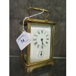 A brass carriage clock, of conventional design with oval glass top plate and enamel dial with