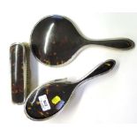 A set of three silver and faux tortoiseshell mirror and brush set, as found