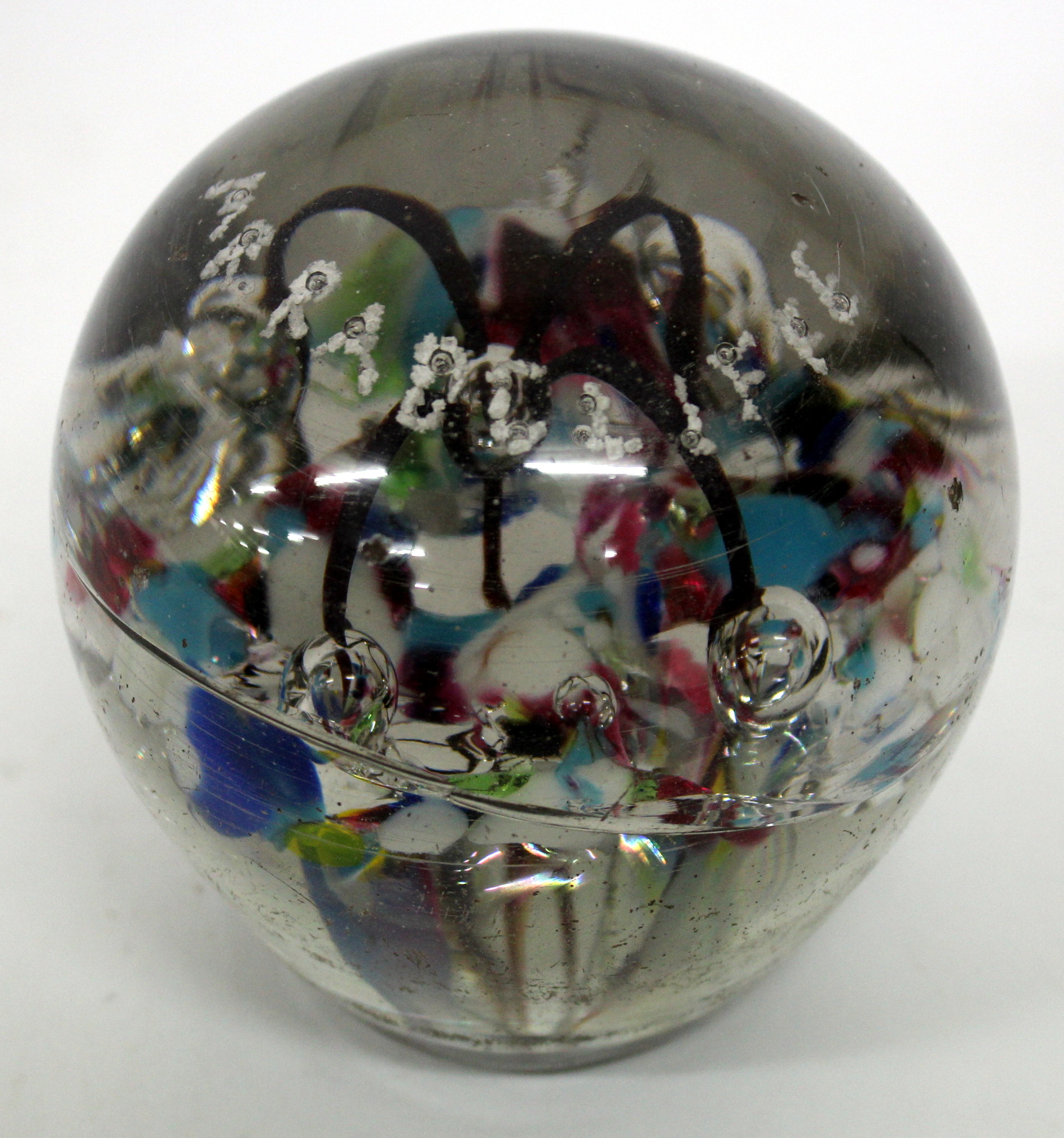 A VICTORIAN DUMP GLASS PAPERWEIGHT of domed form containing bubbles and various enamel colours