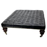 A LARGE BLACK LEATHER BUTTON UPHOLSTERED RECTANGULAR STOOL with four large turned mahogany feet