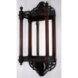 AN EDWARDIAN MAHOGANY MIRROR BACKED WALL BRACKET with pierced decoration, turned cluster supports