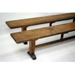 A PAIR OF ARTS AND CRAFTS OAK RECTANGULAR TOPPED BENCHES designed by Edward Barnsley with mortise