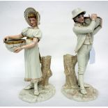 A PAIR OF VICTORIAN ROYAL WORCESTER PORCELAIN FIGURINES of male and female figures carrying baskets,