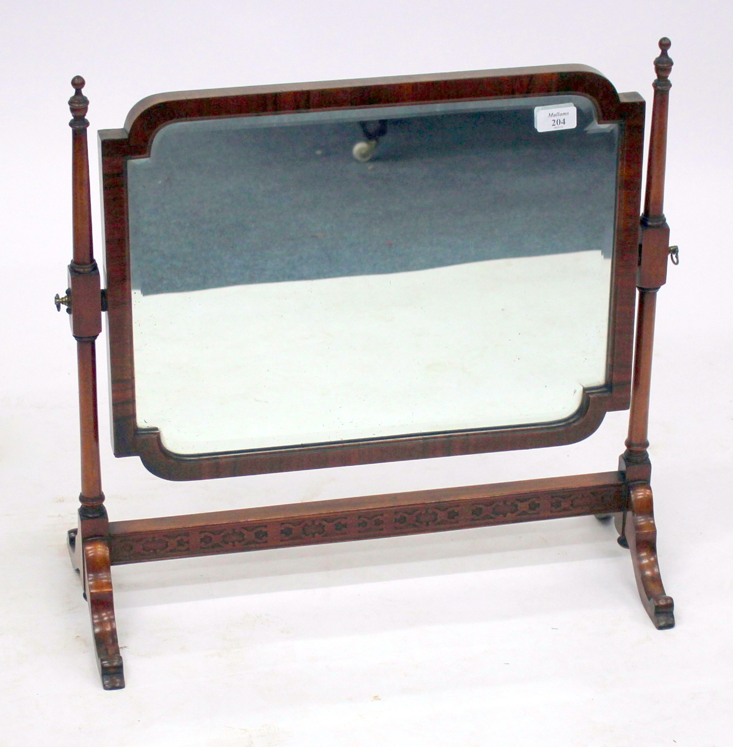 AN 18TH CENTURY STYLE WALNUT FRAMED SWING TOILET MIRROR of shaped rectangular form with turned