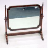 AN 18TH CENTURY STYLE WALNUT FRAMED SWING TOILET MIRROR of shaped rectangular form with turned