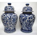 A PAIR OF DECORATIVE BLUE AND WHITE PORCELAIN JARS WITH COVERS each of baluster form with floral