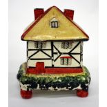 AN ANTIQUE POTTERY PASTILLE BURNER in the form of a thatched cottage, 11cm wide