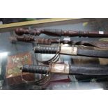 TWO OLD SWORDS in scabbards together with two carved hardwood walking sticks (4)