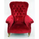 AN OLD RED DRAYLON BUTTON UPHOLSTERED ARMCHAIR with turned tapering front legs terminating in