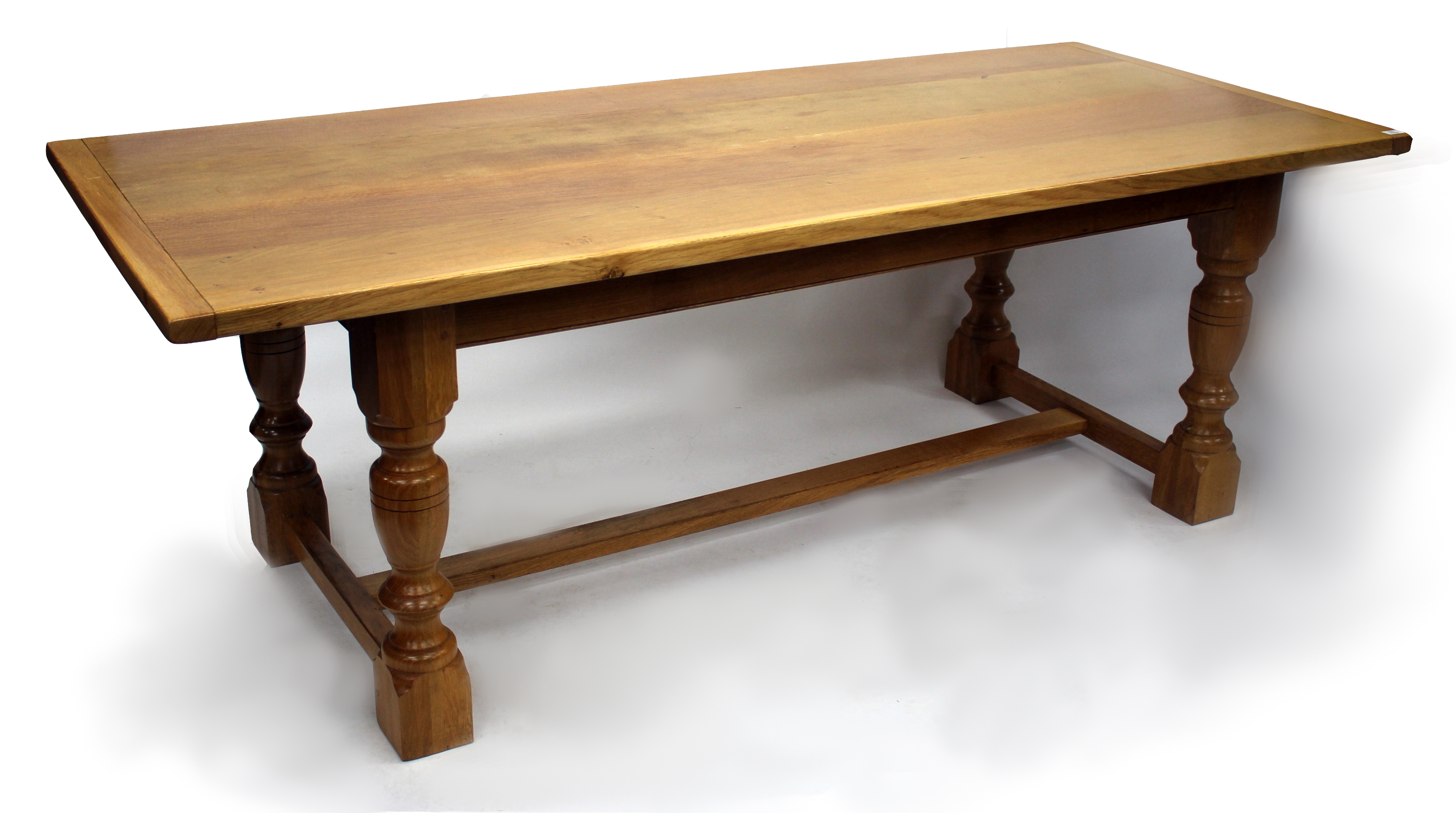 A LIGHT OAK REFECTORY TABLE, the rectangular top with framed ends above baluster turned legs and