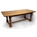 A LIGHT OAK REFECTORY TABLE, the rectangular top with framed ends above baluster turned legs and