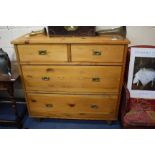 A PINE CHEST OF TWO SHORT AND TWO LONG DRAWERS with inset brass handles and on turned feet, 110cm