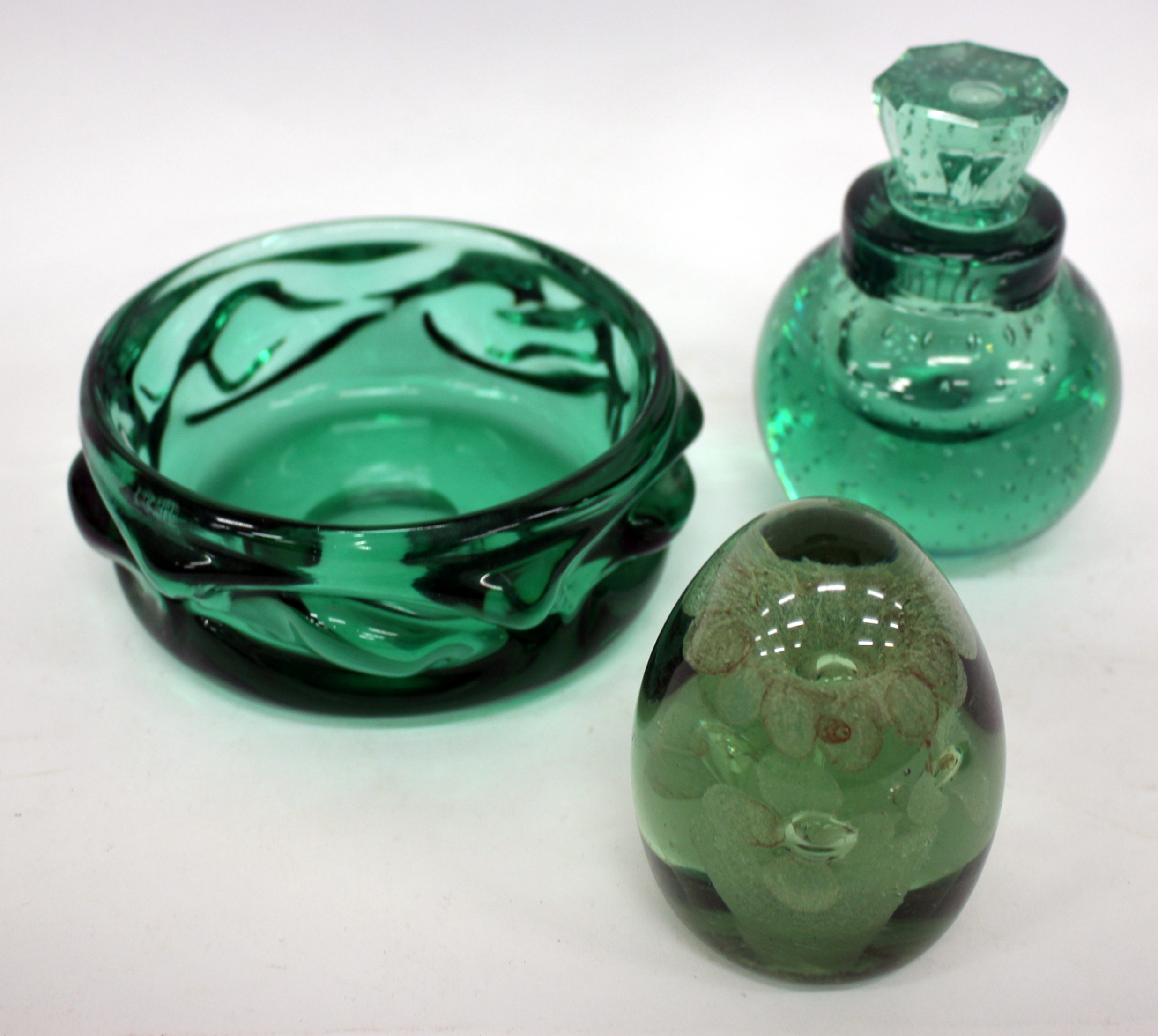 A GREEN GLASS DUMP, the inside inset with flower decoration, 10cm high; a heavy green glass