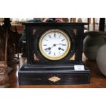 A VICTORIAN BLACK SLATE MANTEL CLOCK, the circular white enamel dial with Roman numerals and