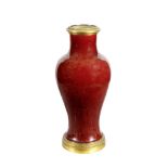 AN ANTIQUE CHINESE PORCELAIN VASE of inverted baluster form and glazed in ox blood red with ormolu