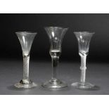 AN 18TH CENTURY WINE GLASS with bell shaped bowl, air twist stem with central moulded knop and