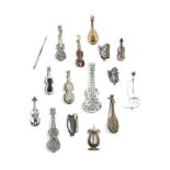 FOUR CONTINENTAL WHITE METAL FILIGREE BROOCHES in the form of musical instruments, two guitars, a