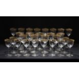 A SUITE OF DRINKING GLASSES with gilded decoration consisting of eight champagne flutes, nine