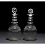 A PAIR OF GEORGIAN IRISH THREE RING DECANTERS with moulded stoppers and engraved ribbon tied swag