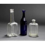 AN ANTIQUE CRUCIFORM BOTTLE 28cm high together with a blue glass moulded bottle 27cm high, and a