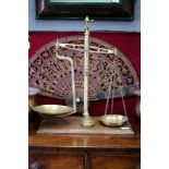 A SET OF OLD BRASS SHOP SCALES, class 1 on a mahogany rectangular base and with a small group of