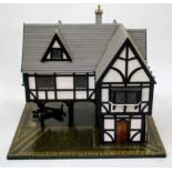 A HANDMADE TUDOR STYLE DOLLS HOUSE painted in black and white, having leaded glass windows and stilt