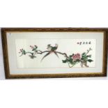 AN ORIENTAL SILKWORK PICTURE of two exotic birds on a flowering branch 31.5cm x 69cm