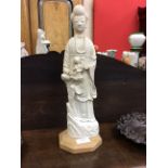 A CHINESE BLANC DE CHINE MODEL of Guanyin holding a child on a later stand, 18th/19th Century,