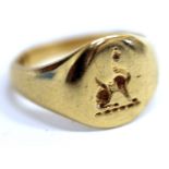 AN 18 CARAT GOLD SIGNET RING decorated with a crest of an animal, marks for London 1940