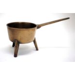 AN ANTIQUE CAST BRONZE SKILLET on three feet 16.5cm diameter