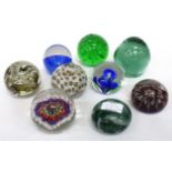 NINE GLASS PAPERWEIGHTS to include an antique green glass dump paperweight and various cane