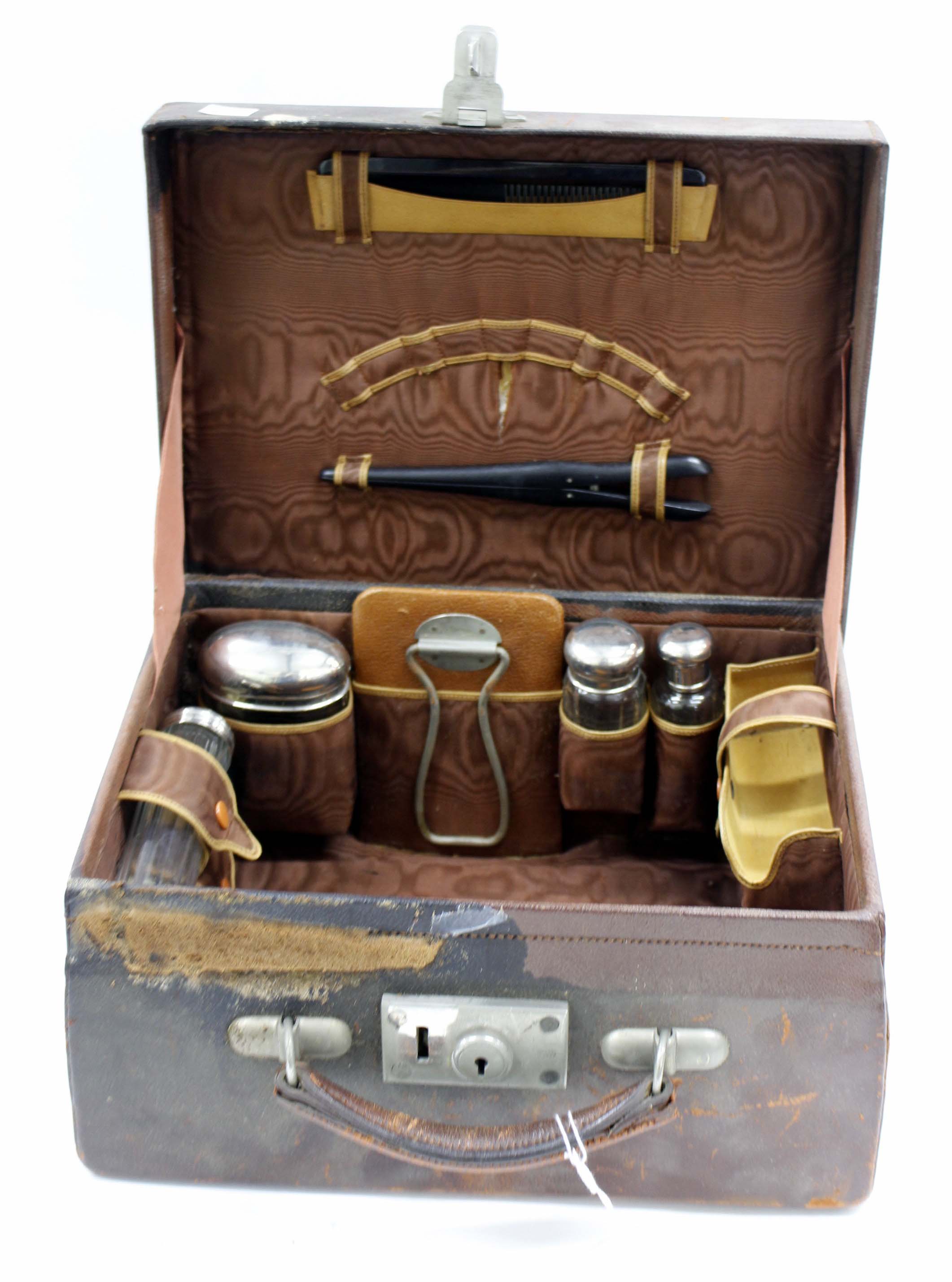 AN ANTIQUE LEATHER SMALL DRESSING CASE with silver plate topped bottles and jars within 33.5cm wide