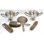 A SILVER BACKED DRESSING TABLE HAND MIRROR together with three matching silver backed brushes and