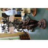 A BRONZED RESIN FIGURAL TABLE LAMP the glass shades depicting flowers 74cm high