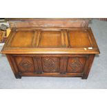 AN OAK COFFER with three panelled top and front and lozenge carved front panels