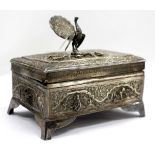 A WHITE METAL BOX mounted with a peacock 16cm wide