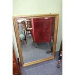 A GILT FRAMED WALL MIRROR 87cm x 113cm