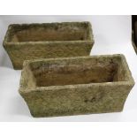 A PAIR OF STONE PLANTERS with carved lozenge and wave decoration to the exterior, 40cm x 17cm x 17cm