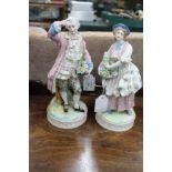 A PAIR OF LATE 19TH / EARLY 20TH CENTURY GERMAN PORCELAIN FIGURES of a man and a woman on circular