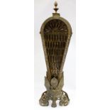 A BRASS PIERCED FAN TYPE FIRE SCREEN decorated with winged creatures 62cm high