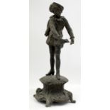 A CAST SPELTER FIGURE OF A CLASSICALLY DRESSED BOY standing on a circular scrolling base, 28cm tall