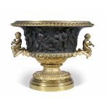 AN OLD FRENCH BRONZE AND GILT BRASS JARDINIERE of oval form with gadrooned rim, the body cast with