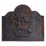 A CAST IRON FIRE BACK decorated with a crest of a horse beneath a tree, the fire back with moulded