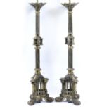 A PAIR OF GOTHIC REVIVAL GILT BRASS ALTAR CANDLESTICKS, the hexagonal columns each centred by a