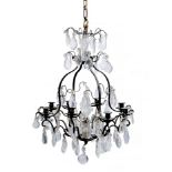 A CONTINENTAL BRASS EIGHT LIGHT CHANDELIER, the swan neck arms supporting cut glass drops around a