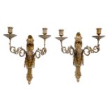 A PAIR OF CAST BRASS WALL SCONCES with scrolling arms and ram's mask decoration, each 34cm wide x