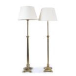 A PAIR OF BRASS LAMP STANDARDS of reeded Corinthian column form and on stepped plinth bases with