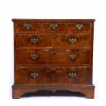 A GEORGE III WALNUT CHEST OF DRAWERS with feather stringing and cross banded decoration to the